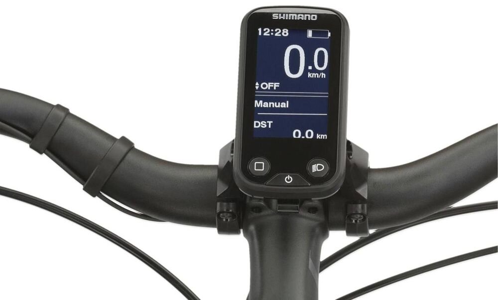 Na zdjęciu widoczny jest wyświetlacz roweru elektrycznego z logo \'SHIMANO\', pokazujący prędkość 0.0 km/h, tryb \'Manual\' oraz dystans 0.0 km. Kierownica roweru jest czarna, a wyświetlacz ma kilka przycisków nawigacyjnych.