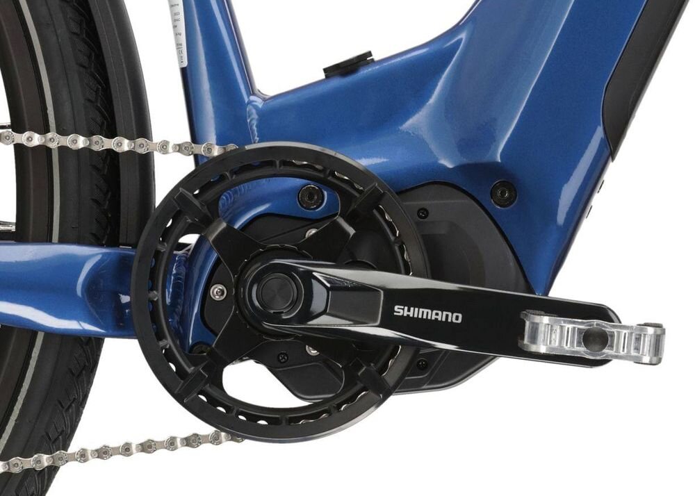 Zbliżenie na mechanizm napędowy roweru elektrycznego w kolorze niebiesko-czarnym z widocznym logo \'SHIMANO\' na ramieniu korby.
