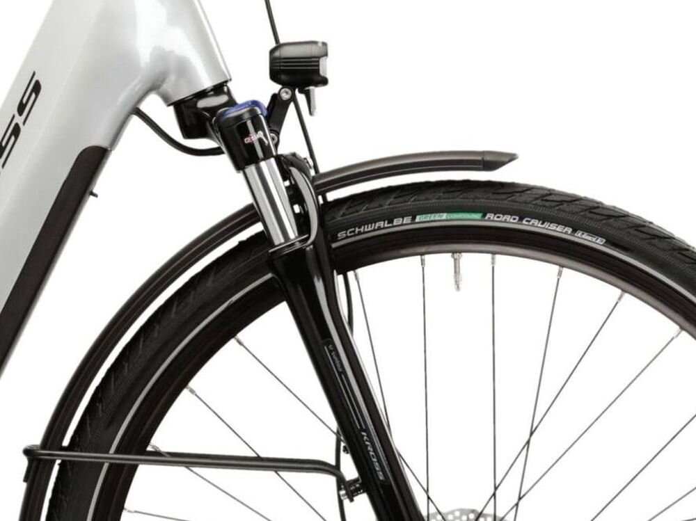 Zbliżenie na przednie koło roweru z widocznym amortyzatorem i błotnikiem. Na oponie widoczny jest napis \'SCHWALBE ROAD CRUISER\'.