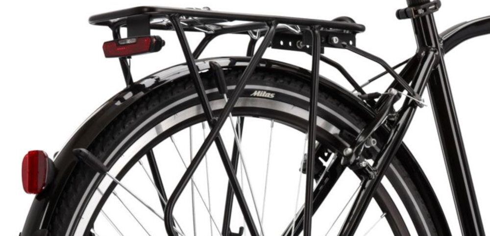 Rower trekkingowy KROSS Trans 4.0 M17 28 cali męski Czarno-szary zbliżenie na bagażnik widok od tyłu pod skosem białe tło bagażnik wygodne przewożenie dodatkowego ekwipunku stabilna konstrukcja bezpieczne mocowanie składana stopka zamontowana w centralnym punkcie ciężkości stabilność podczas postoju ciężar pojazdu rozkłada się równomiernie