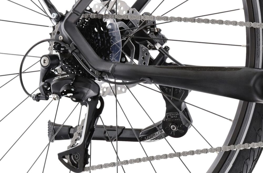 Zbliżenie na mechanizm napędowy roweru z widocznym łańcuchem, przerzutką i tarczą hamulcową. Elementy są w kolorze czarnym z metalicznymi akcentami.