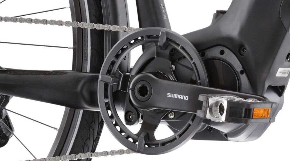 Zbliżenie na mechanizm korbowy roweru z widocznym napisem \'SHIMANO\'.