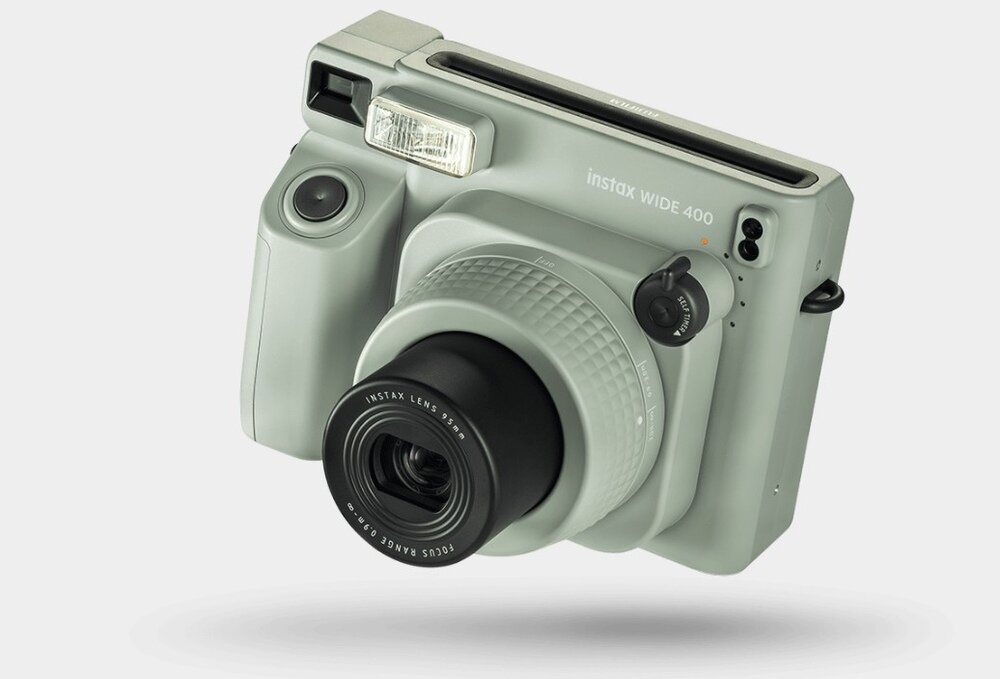 Zielony aparat natychmiastowy z napisem \'instax WIDE 400\' na obudowie, posiadający duży obiektyw i wbudowaną lampę błyskową.