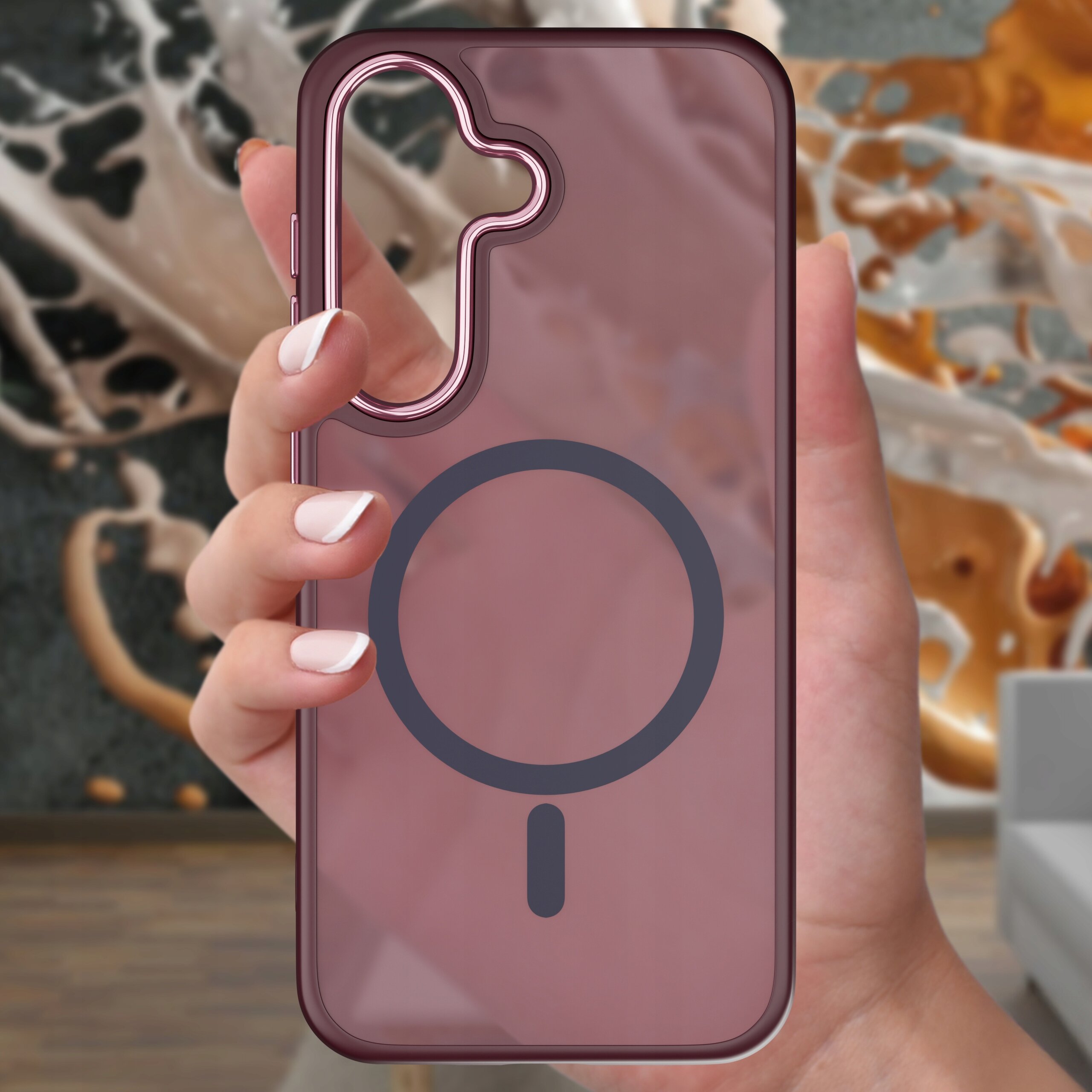 Osoba trzyma przezroczyste etui na telefon z widocznym okrągłym wzorem na środku. W tle znajduje się rozmyty wzór przypominający rozpryski cieczy.