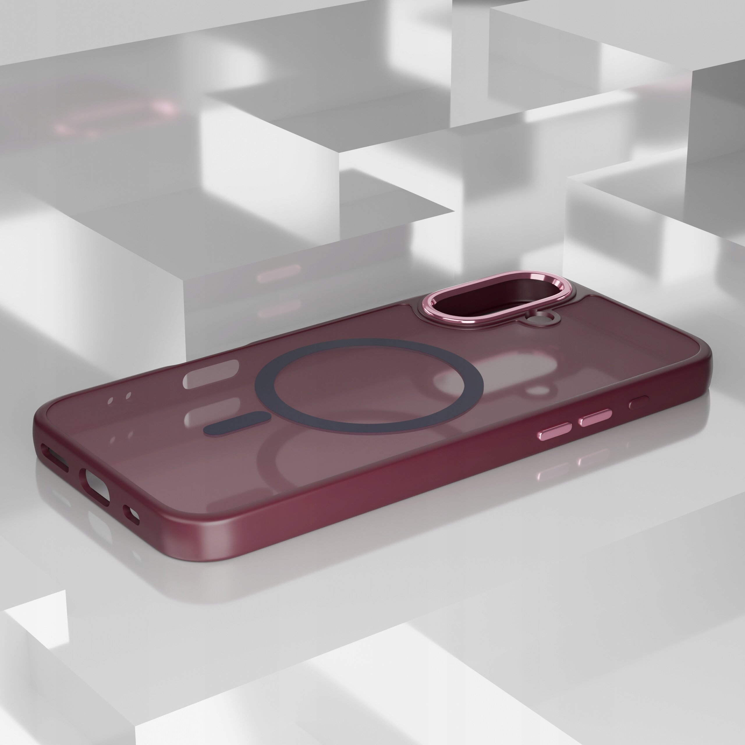 Etui w kolorze bordowym z okrągłym wzorem na środku, przeznaczone do iPhone 17, leży na białej, geometrycznej powierzchni. Posiada wycięcia na przyciski i aparat oraz metaliczne wykończenie wokół otworu na kamerę.