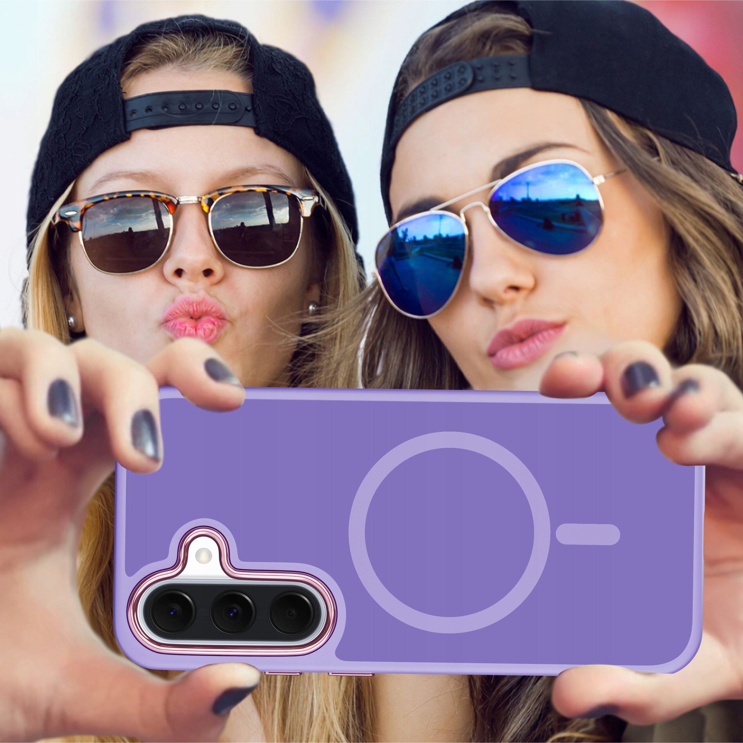 Dwie osoby w okularach przeciwsłonecznych trzymają fioletowe etui na telefon z widocznym okręgiem i miejscem na aparat. Etui jest matowe i przeznaczone do Samsunga A57 5G z funkcją Magsafe.