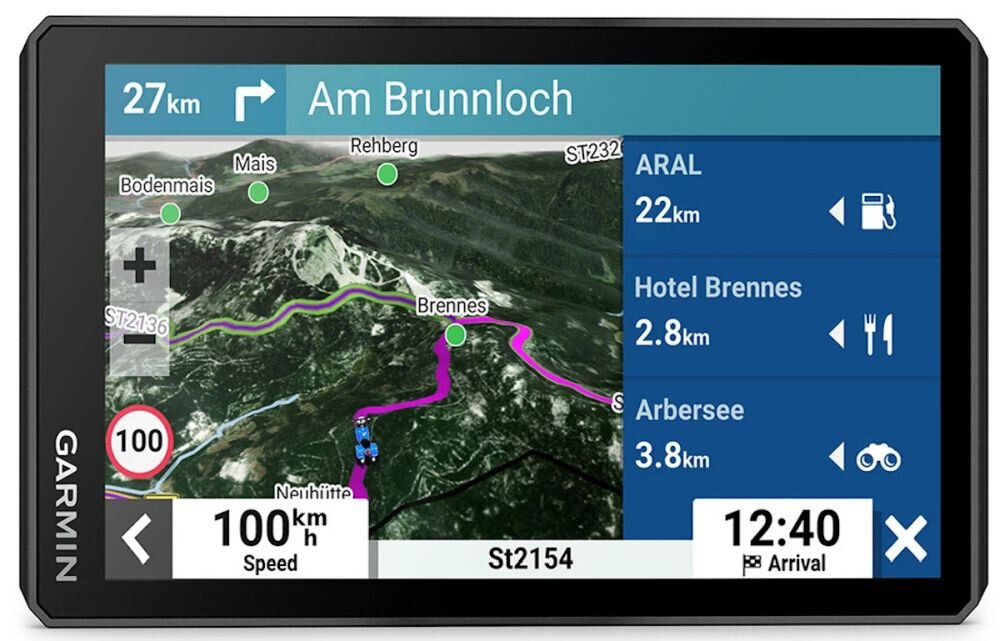 Ekran nawigacji motocyklowej Garmin Zumo XT2 pokazuje mapę z trasą oznaczoną fioletową linią oraz informacje o prędkości 100 km/h i przewidywanym czasie przybycia 12:40. Po prawej stronie widoczne są punkty POI: ARAL 22 km, Hotel Brennes 2.8 km, Arbersee 3.8 km.