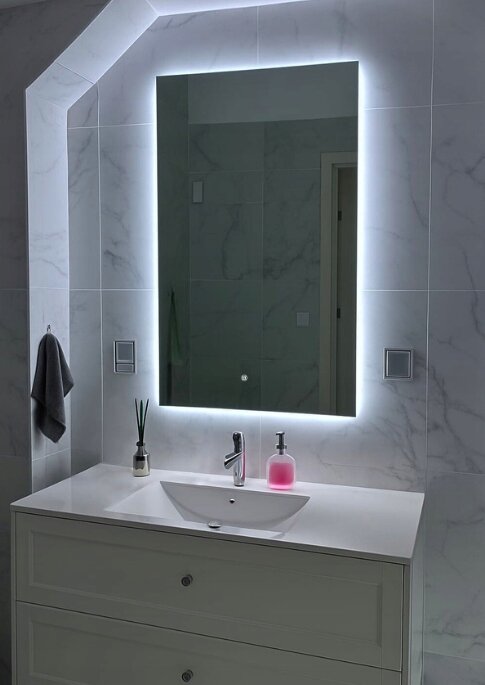 Lustro LED o wymiarach 60x90 cm z podświetleniem na krawędziach, zamontowane nad umywalką w łazience z marmurowymi płytkami na ścianie.