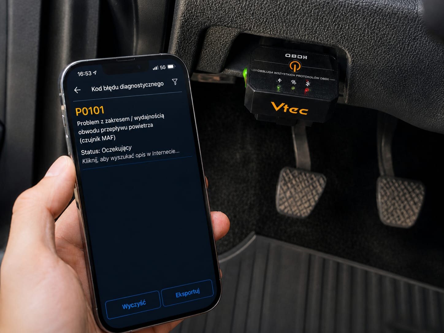 Osoba trzyma smartfon z aplikacją pokazującą kod błędu diagnostycznego P0101, dotyczący problemu z przepływem powietrza. Obok znajduje się podłączony interfejs diagnostyczny OBD2 z widocznym logo Vtec.