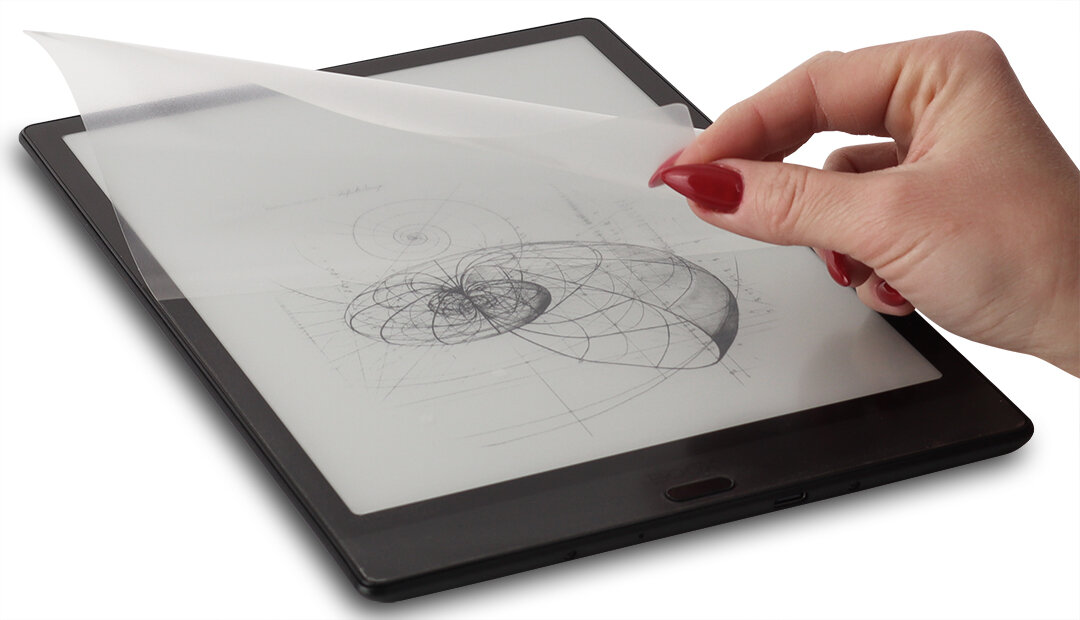 Osoba nakłada folię ochronną na ekran tabletu, na którym widoczny jest schematyczny rysunek geometryczny.