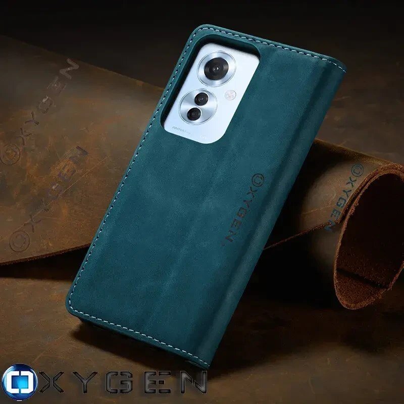 Etui na telefon w kolorze ciemnozielonym z widocznym logo \'OXYGEN\', leży na tle z brązowej skóry. Widać wycięcie na aparat telefonu z trzema obiektywami.