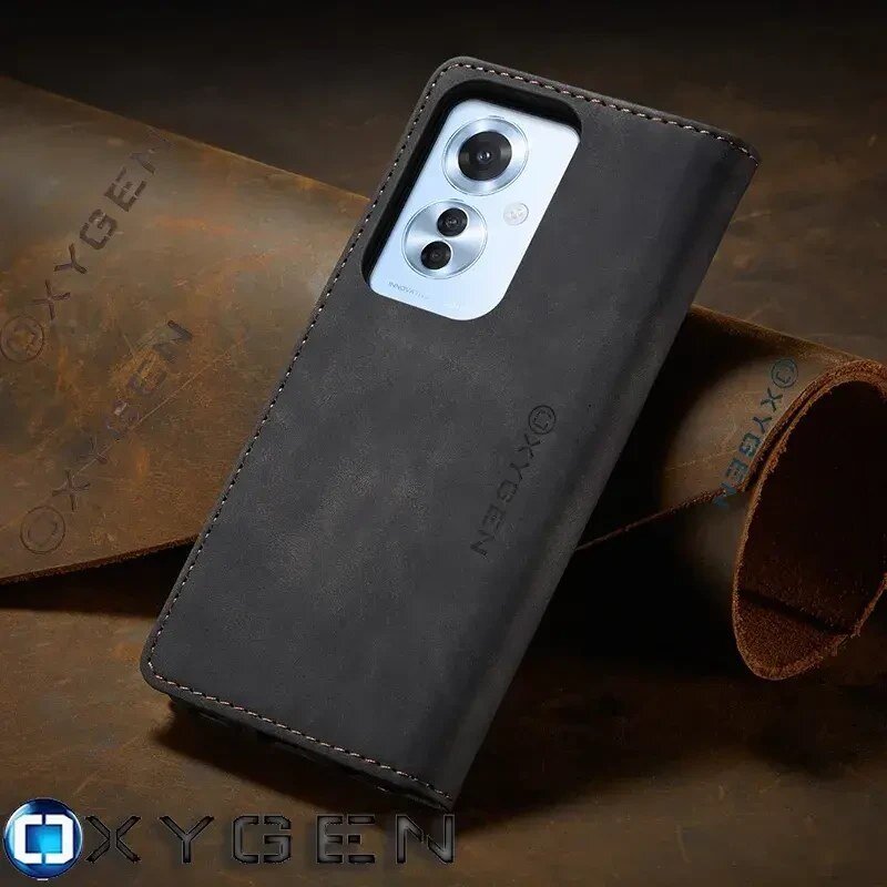 Czarne etui na telefon z widocznym logo \'OXYGEN\', z trzema otworami na aparaty fotograficzne. W tle znajduje się materiał z wytłoczonym napisem \'OXYGEN\'.