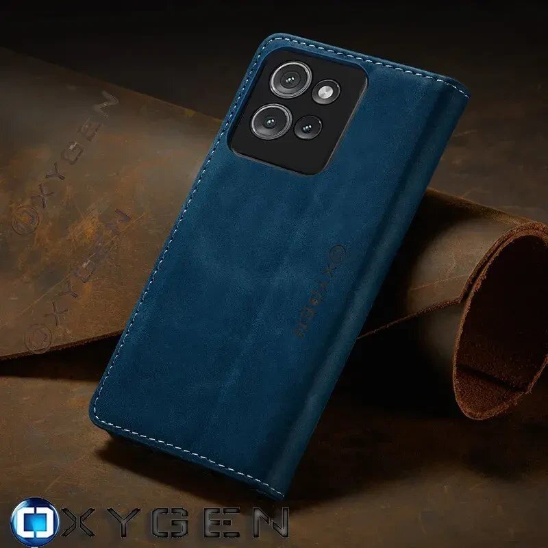 Na zdjęciu widoczne jest niebieskie etui na telefon z trzema wycięciami na aparaty, leżące na brązowym tle. Na etui oraz w dolnej części obrazu widnieje napis \'OXYGEN\'.