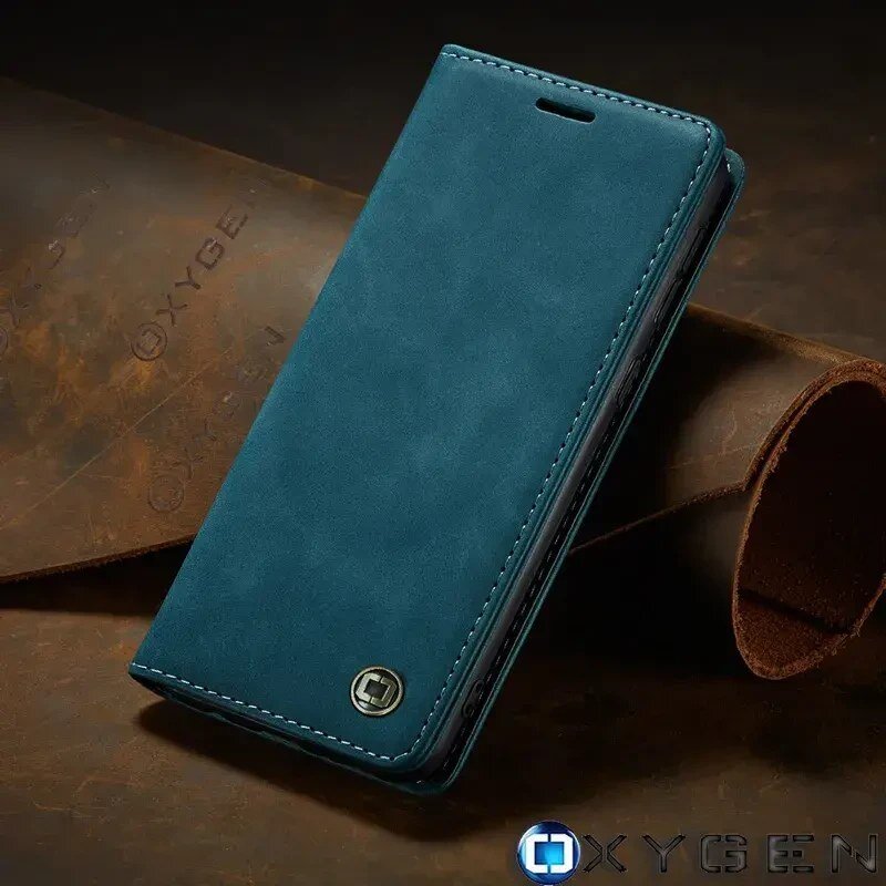Na obrazie widoczne jest niebieskie etui na telefon z logo OXYGEN w dolnym rogu. W tle znajduje się brązowy materiał z wytłoczonym napisem \'OXYGEN\'.