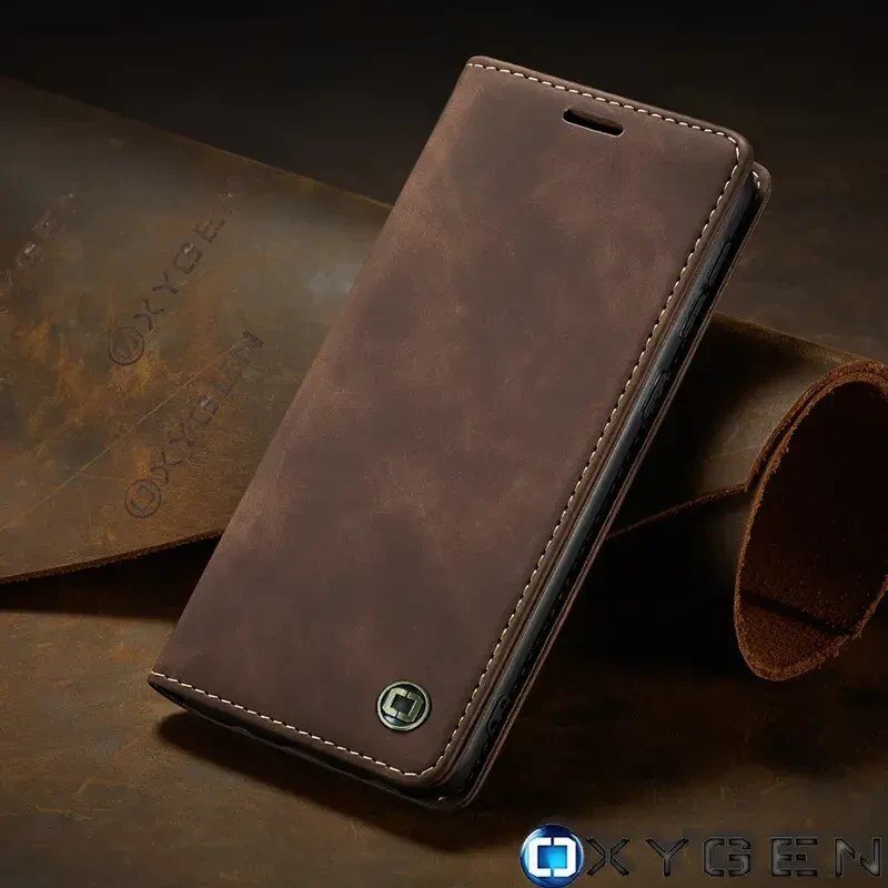 Brązowe etui na telefon z widocznym logo OXYGEN, wykonane z materiału imitującego skórę. W tle znajduje się materiał z wytłoczonym napisem OXYGEN.