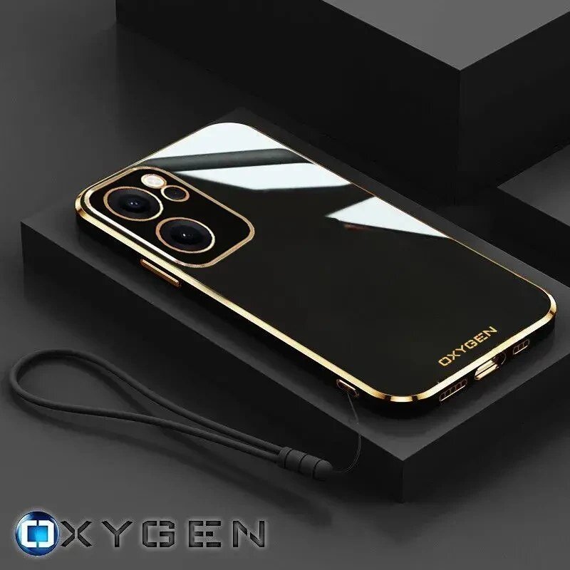 Na obrazie widoczne jest eleganckie etui na telefon z czarną, błyszczącą powierzchnią i złotymi krawędziami. Na etui znajduje się napis \'OXYGEN\', a obok widoczny jest czarny pasek na rękę.
