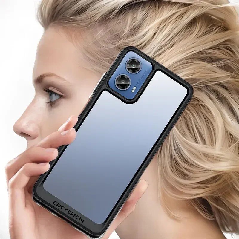 Osoba trzyma telefon w etui z napisem \'OXYGEN\', z widocznymi dwoma obiektywami aparatu. Tło jest rozmyte, skupiając uwagę na etui i telefonie.