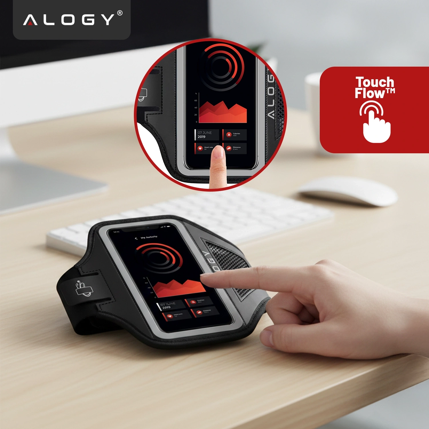Na biurku leży czarna opaska na ramię z telefonem w środku, na ekranie widoczny jest wykres. W prawym górnym rogu znajduje się czerwony symbol z napisem \'Touch Flow™\'.