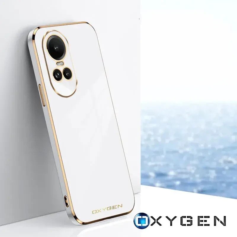 Na obrazie widoczne jest białe etui na telefon z trzema otworami na aparaty, ozdobione złotymi akcentami. W prawym dolnym rogu znajduje się logo \'OXYGEN\'.
