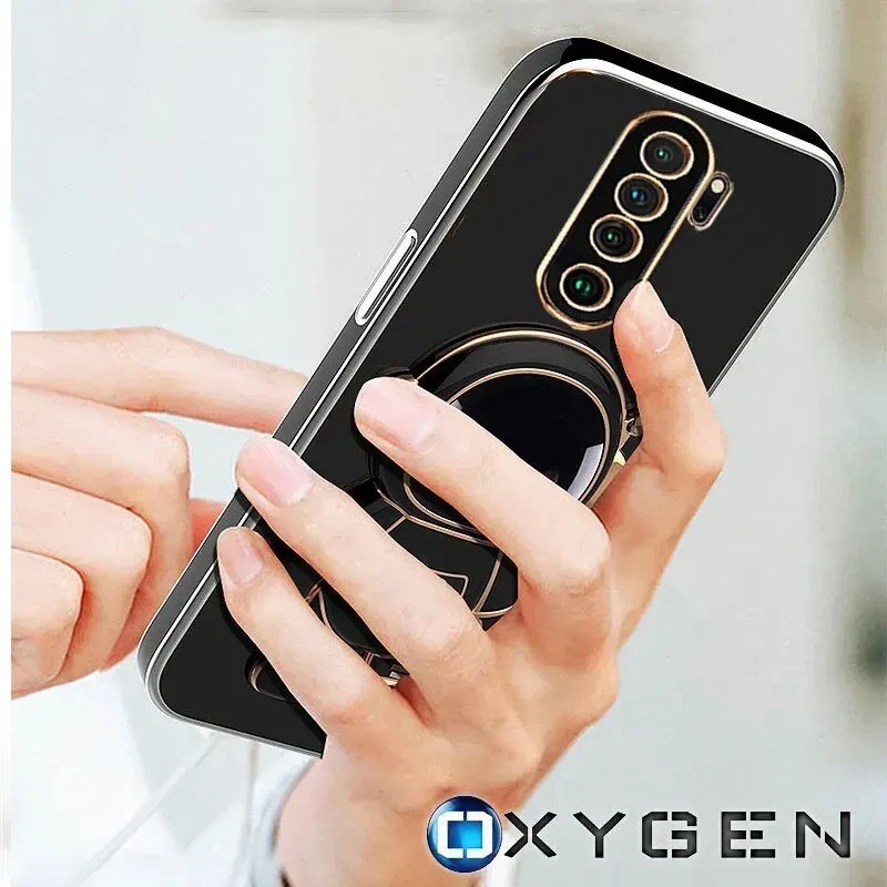 Osoba trzyma telefon w czarnym etui z grafiką astronauty, widoczne są cztery obiektywy aparatu. Na dole znajduje się logo \'OXYGEN\'.