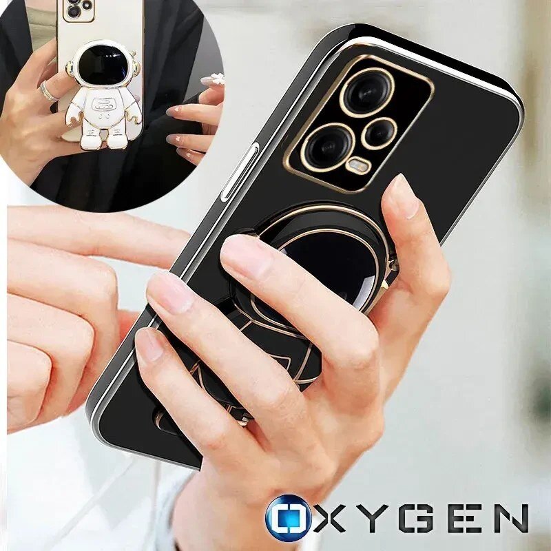 Osoba trzyma telefon w czarnym etui z motywem astronauty, a w tle widoczne jest logo OXYGEN.