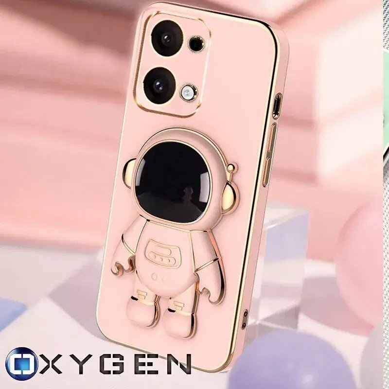 Różowe etui na telefon z wytłoczonym wzorem astronauty, posiada wycięcia na dwa aparaty i logo OXYGEN. Tło jest rozmyte, w pastelowych kolorach.