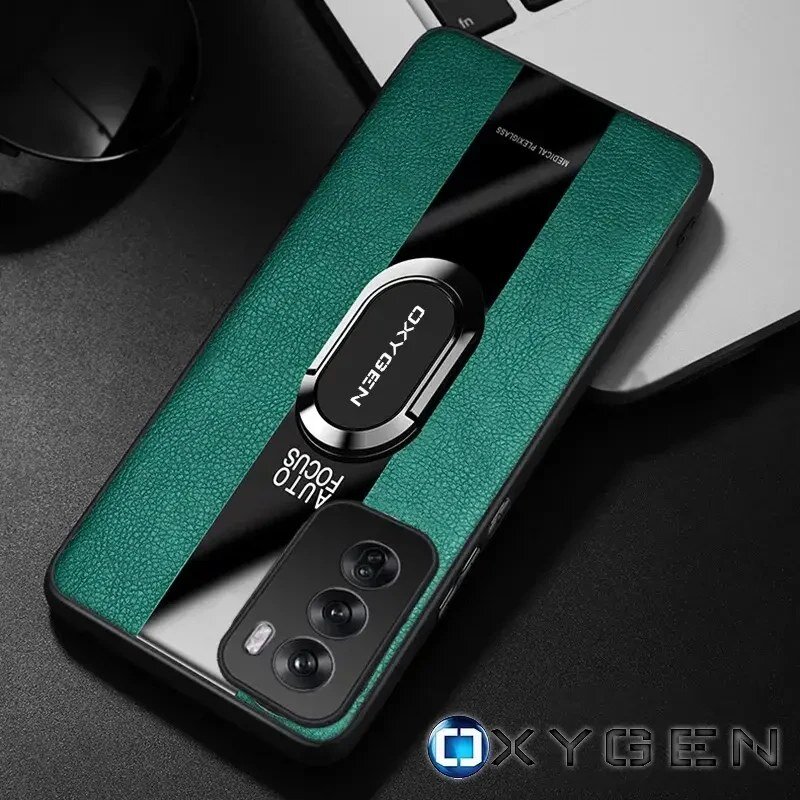 Etui na telefon w kolorze zielonym z czarnym paskiem i napisem \'OXYGEN AUTO FOCUS\'. W tle widoczna jest część klawiatury laptopa i okulary przeciwsłoneczne.