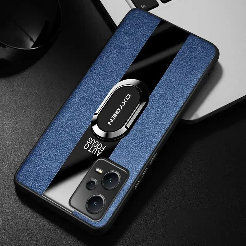 Etui na telefon w kolorze niebieskim z czarnym paskiem i napisem \'OXYGEN\' oraz \'AUTO FOCUS\'. W tle widoczna jest część klawiatury laptopa.