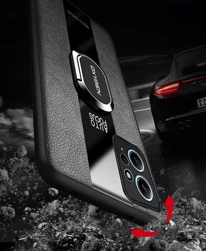 Na obrazie widoczne jest etui na telefon z napisem \'OXYGEN\' oraz \'AUTO FOCUS\', z metalowym uchwytem na środku. W tle znajduje się samochód sportowy na drodze.