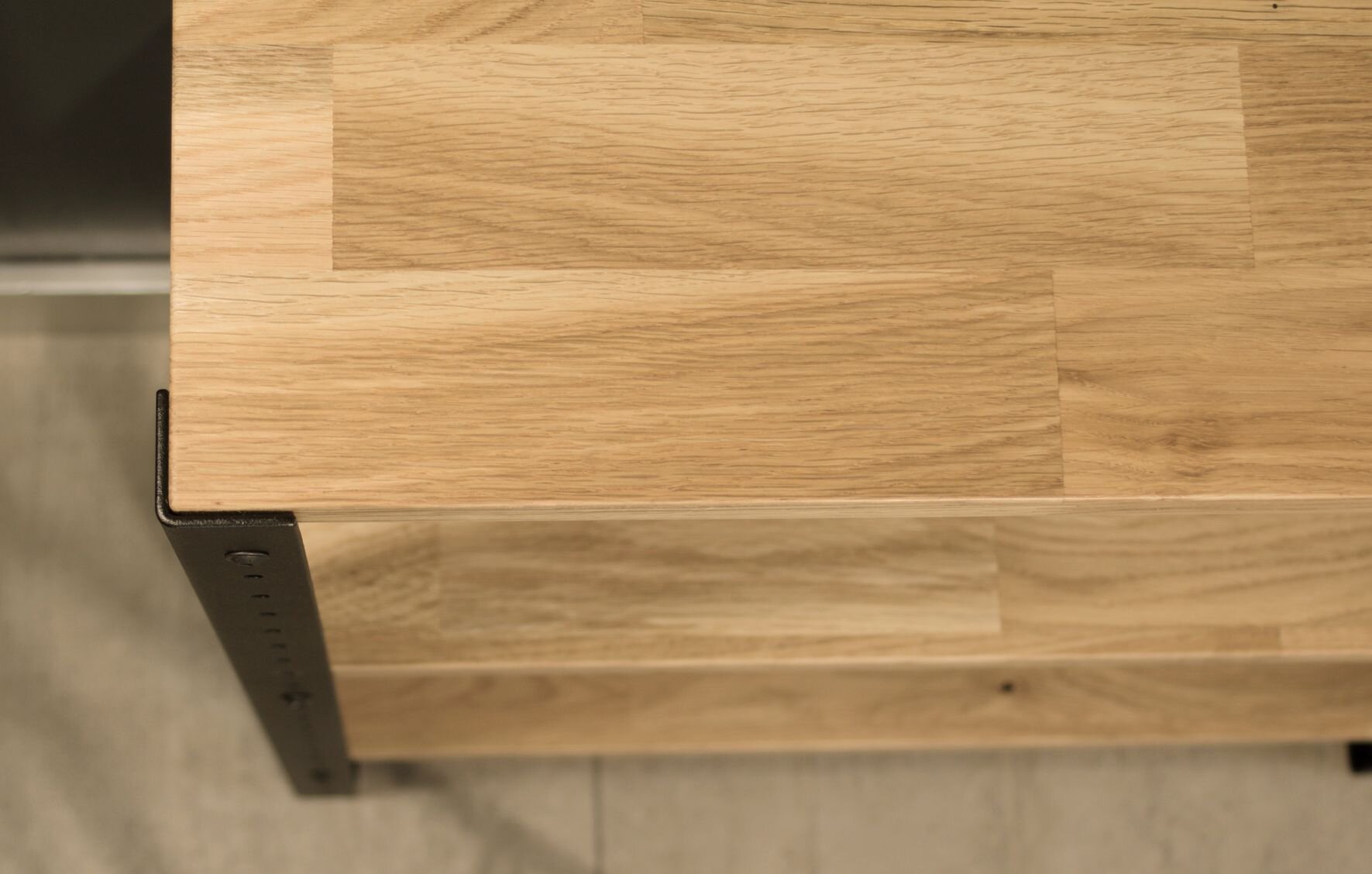 Zdjęcie przedstawia fragment regału wykonanego z jasnego drewna dębowego z metalowymi elementami konstrukcyjnymi.