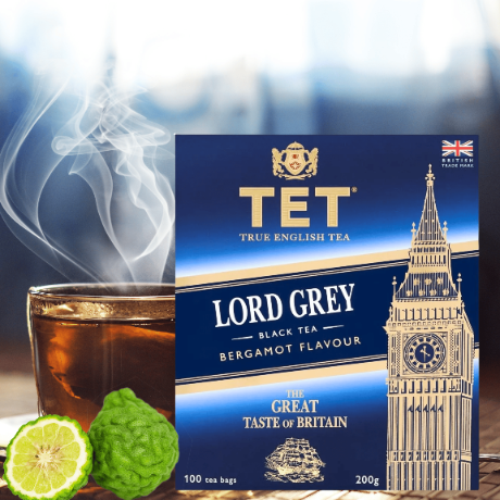 Opakowanie herbaty TET Lord Grey z aromatem bergamotki, obok filiżanka parującej herbaty i owoc bergamotki. Na opakowaniu widoczny jest wizerunek Big Bena oraz napisy: \'TET True English Tea\', \'Lord Grey Black Tea Bergamot Flavour\', \'The Great Taste of Britain\', \'100 tea bags\', \'200g\'.