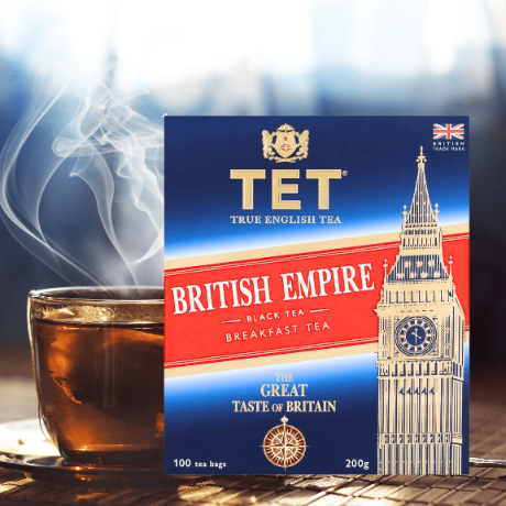 Opakowanie herbaty czarnej Premium TET British Empire 100 torebek 200g z widocznym napisem \'BRITISH EMPIRE BLACK TEA BREAKFAST TEA\' oraz filiżanka z parującą herbatą.