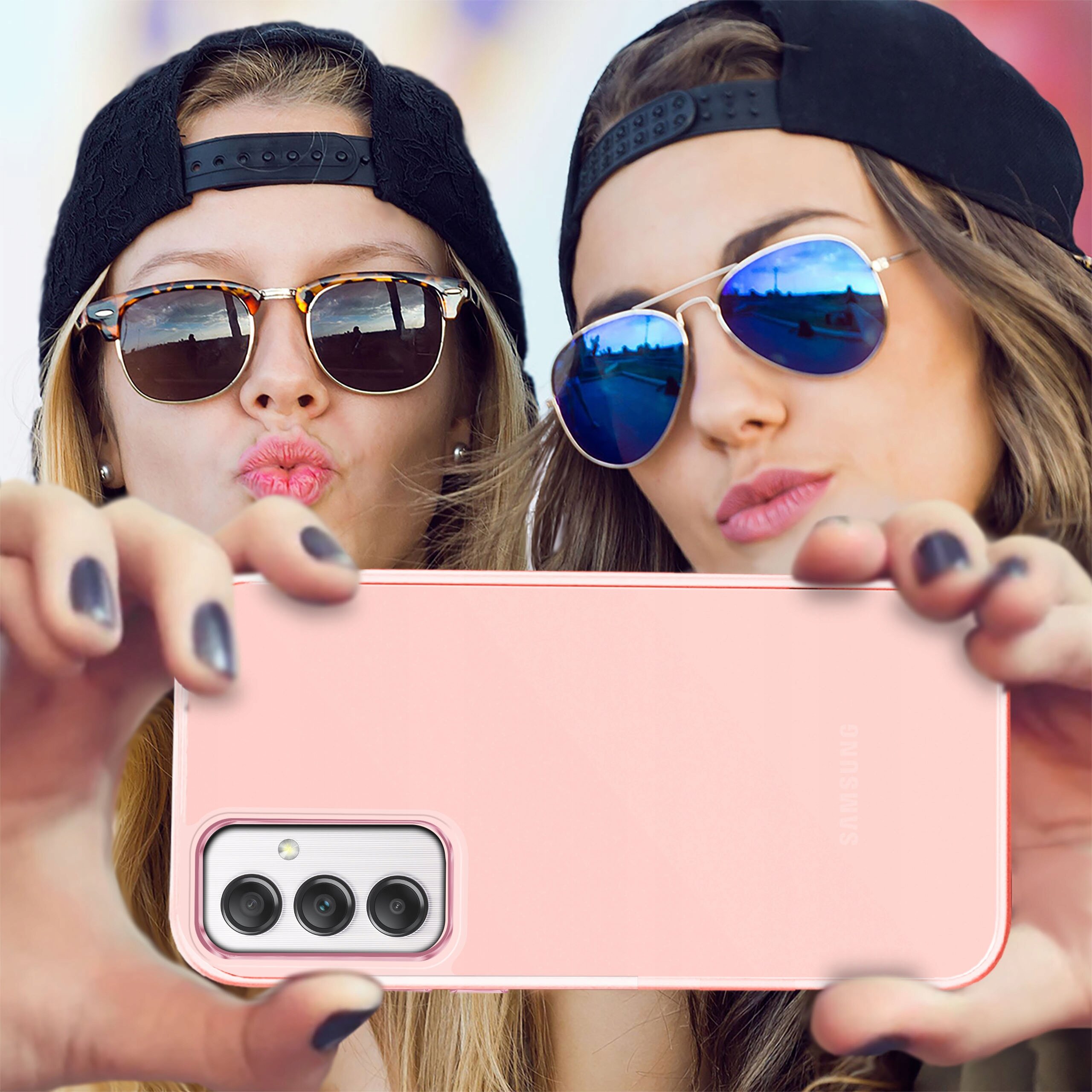 Dwie osoby w okularach przeciwsłonecznych trzymają różowe etui na telefon z trzema obiektywami aparatu. Na etui widoczne jest logo \'Samsung\'.