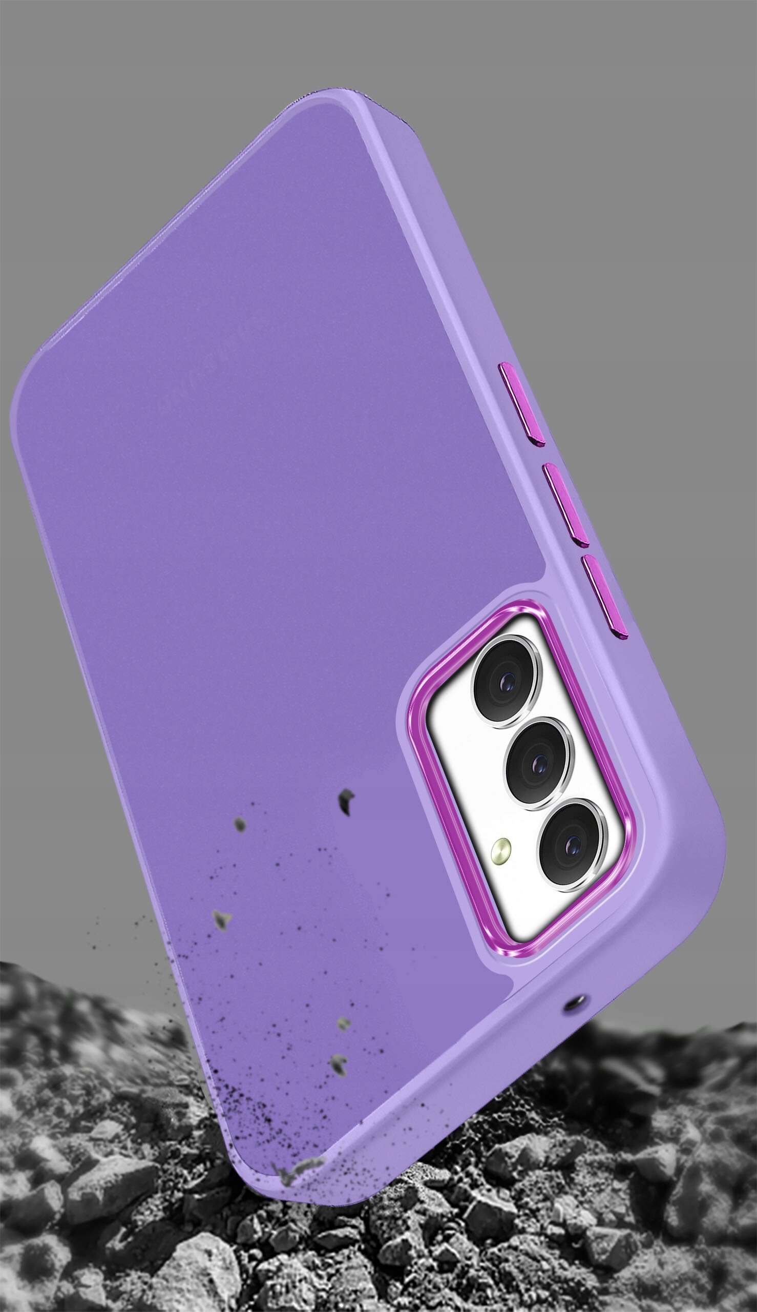 Fioletowe etui na telefon z trzema wycięciami na aparaty, leżące na tle przypominającym kamienie. Etui ma matową powierzchnię i widoczne przyciski boczne.