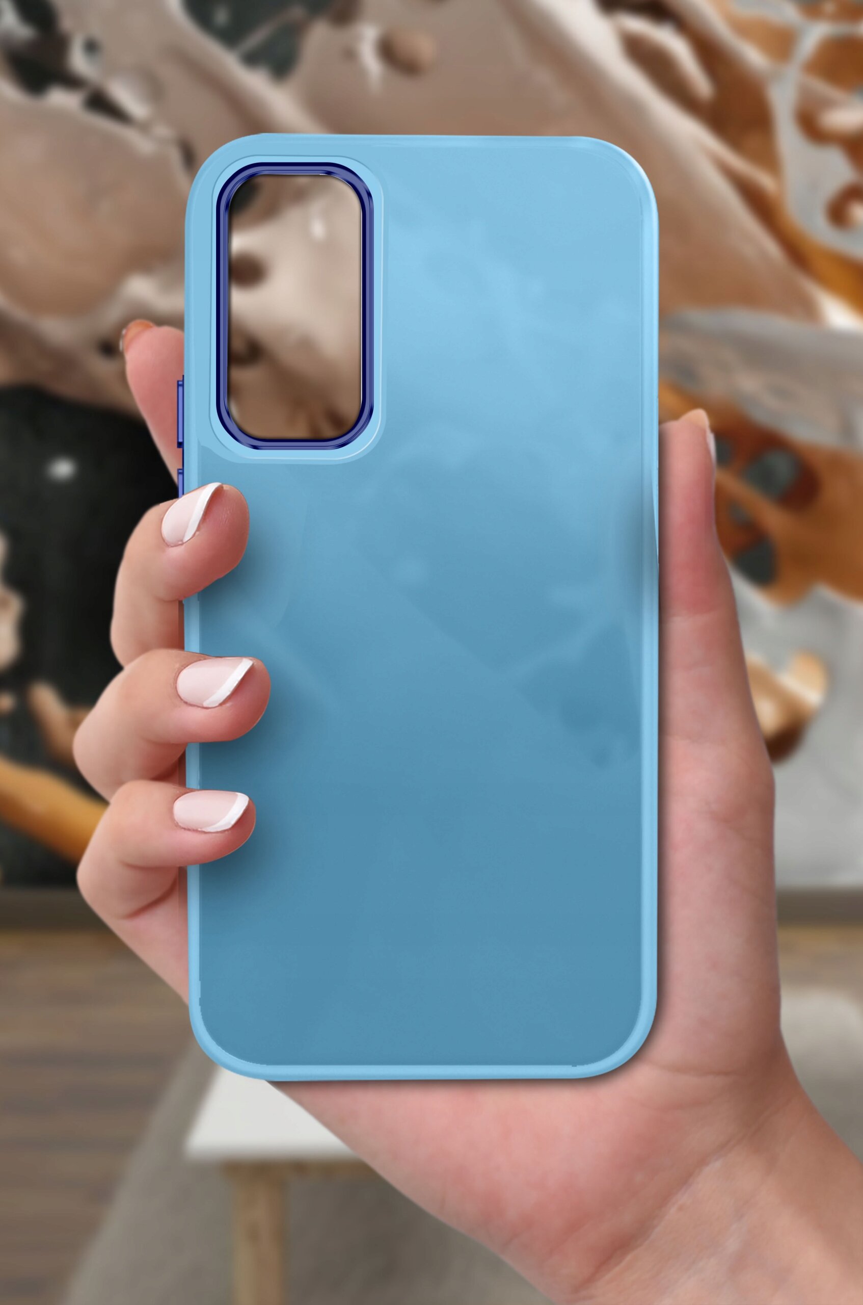 Niebieskie etui na telefon trzymane w dłoni, z wycięciem na aparat w górnej części.