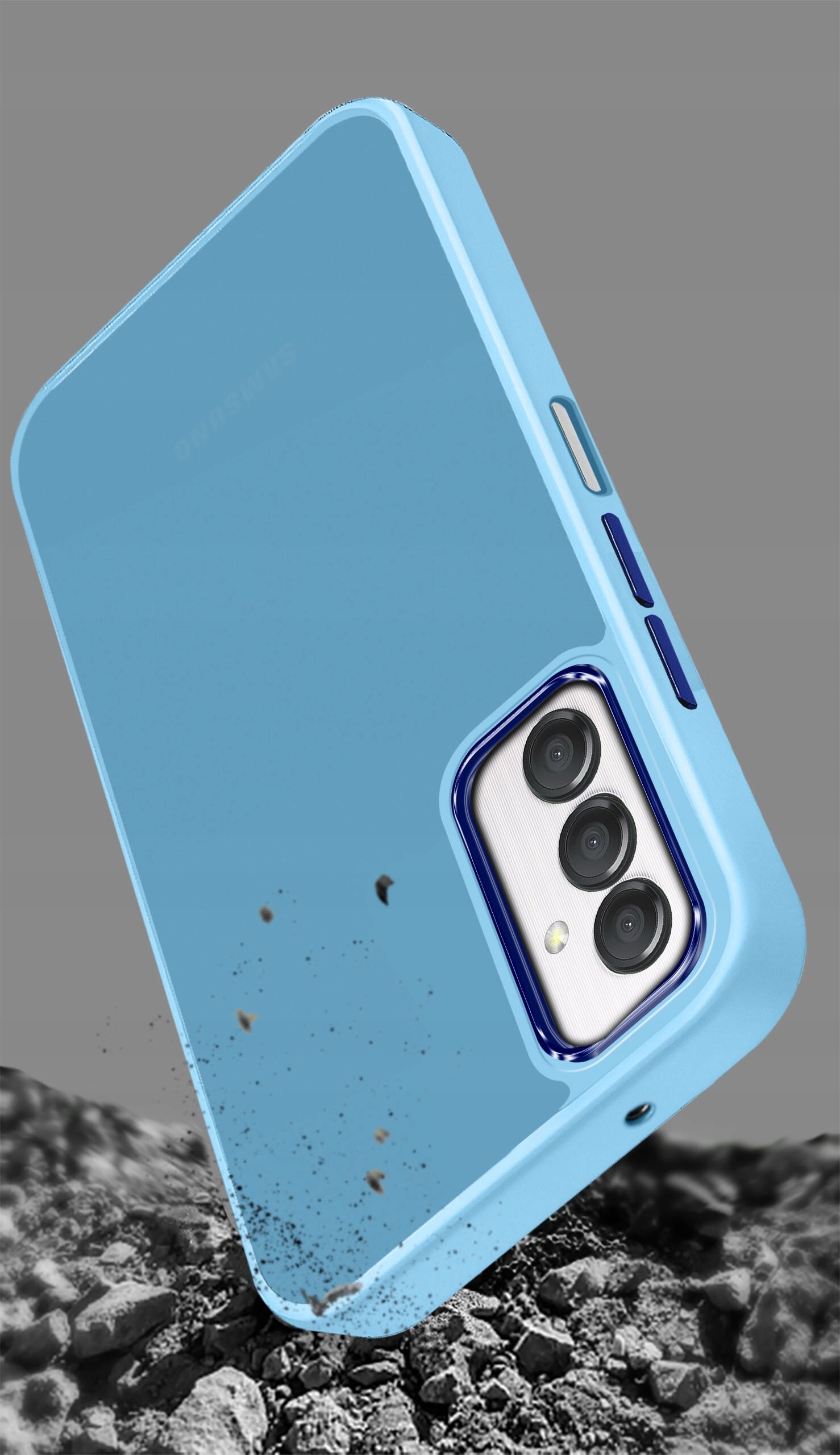 Niebieskie etui na telefon z trzema wycięciami na aparaty, leżące na tle przypominającym kamienie. Etui ma matowe wykończenie i widoczne są przyciski boczne.