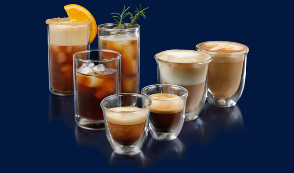 Na ciemnoniebieskim tle znajduje się sześć szklanek z różnymi napojami kawowymi, w tym kawa z lodem, espresso i cappuccino. Niektóre szklanki mają dekoracje, takie jak plasterek pomarańczy lub gałązka rozmarynu.