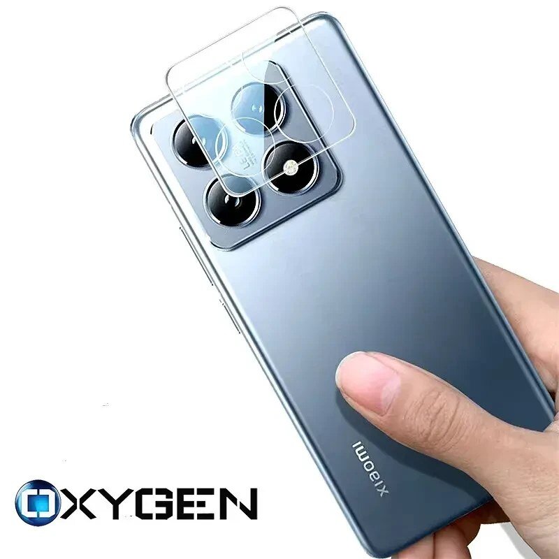 Osoba trzyma smartfon z widocznym zestawem czterech obiektywów aparatu, na który nakładane jest szkło ochronne. W dolnej części obrazu znajduje się logo \'OXYGEN\'.