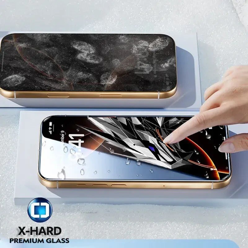 Na zdjęciu widoczny jest telefon z nałożonym szkłem ochronnym, na którym znajdują się odciski palców, oraz drugi telefon z wyświetlaczem pokazującym abstrakcyjną grafikę. W dolnej części zdjęcia znajduje się logo X-HARD PREMIUM GLASS.