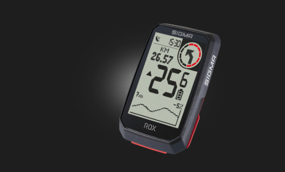 Licznik rowerowy z wyświetlaczem pokazującym czas 15:30, dystans 26.57 KM, temperaturę -25°C oraz wykres wysokości. Na obudowie widoczne jest logo SIGMA.