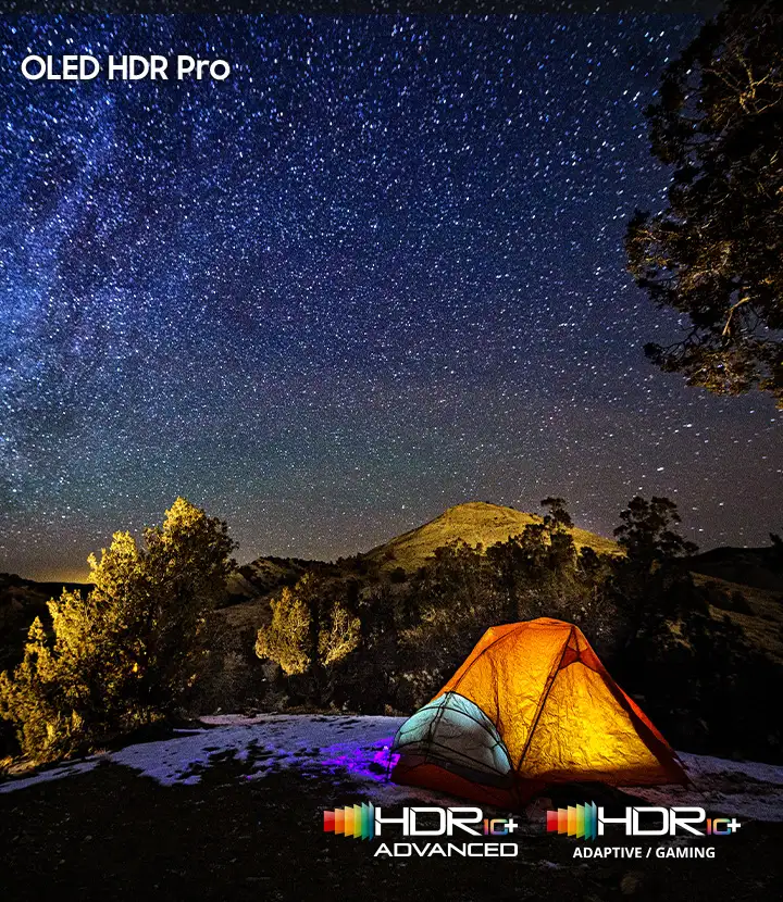 2026-oled-oled-hdr-pro-mo 720x830 Nocne niebo pełne gwiazd nad oświetlonym namiotem na tle wzgórza i drzew. Widoczny tekst: \'OLED HDR Pro\', \'HDR 10+ ADVANCED\', \'HDR 10+ ADAPTIVE / GAMING\'.