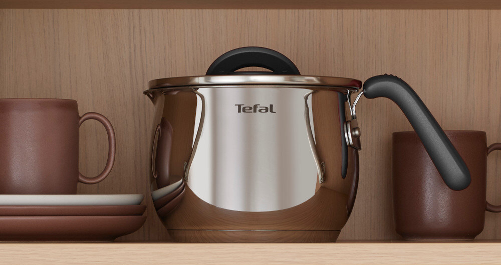 Na półce znajduje się metalowy garnek z czarnym uchwytem i logo \'Tefal\' na przodzie. Obok garnka stoją brązowe kubki i talerze.