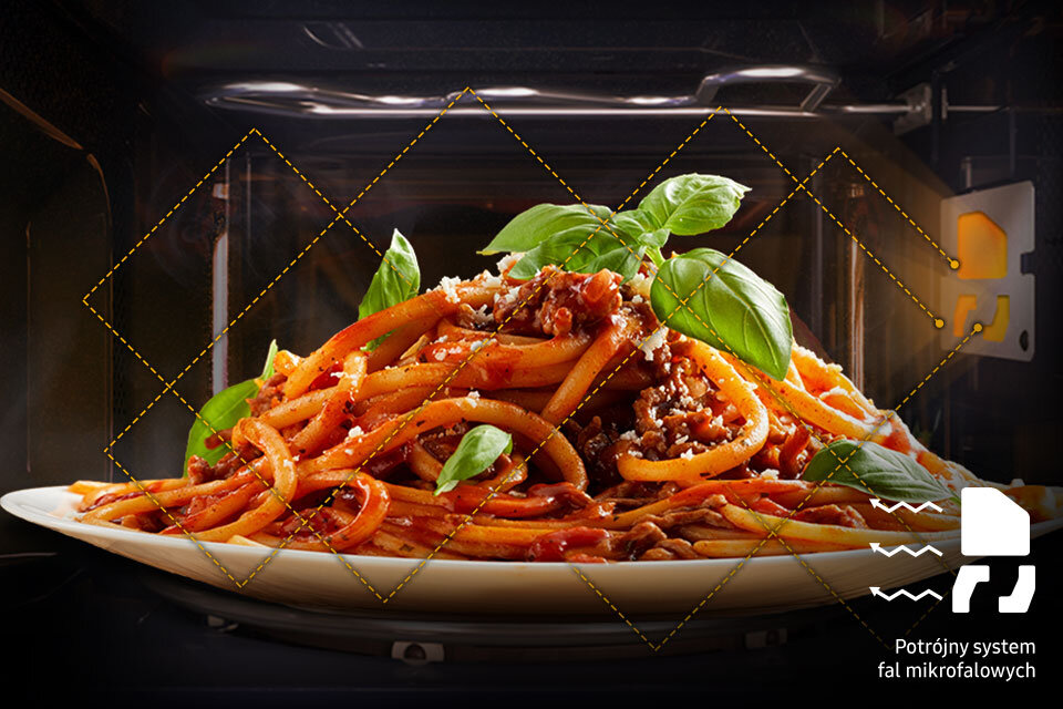Na obrazie widoczny jest talerz spaghetti z sosem i liśćmi bazylii, umieszczony wewnątrz kuchenki mikrofalowej. W prawym dolnym rogu znajduje się tekst: \'Potrójny system fal mikrofalowych\'.