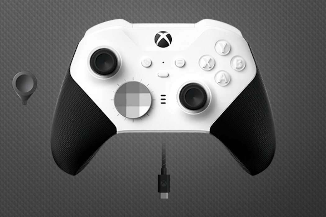 Biały kontroler do gier z czarnymi uchwytami i przyciskami oznaczonymi literami A, B, X, Y. Widoczne jest logo Xbox oraz kabel USB-C poniżej kontrolera.