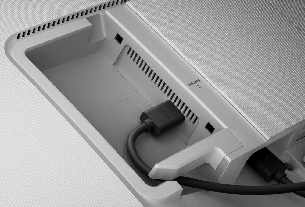 Zdjęcie przedstawia tylną część monitora z widocznym złączem HDMI, do którego podłączony jest kabel. Obok złącza znajduje się napis \'HDMI 2\'.