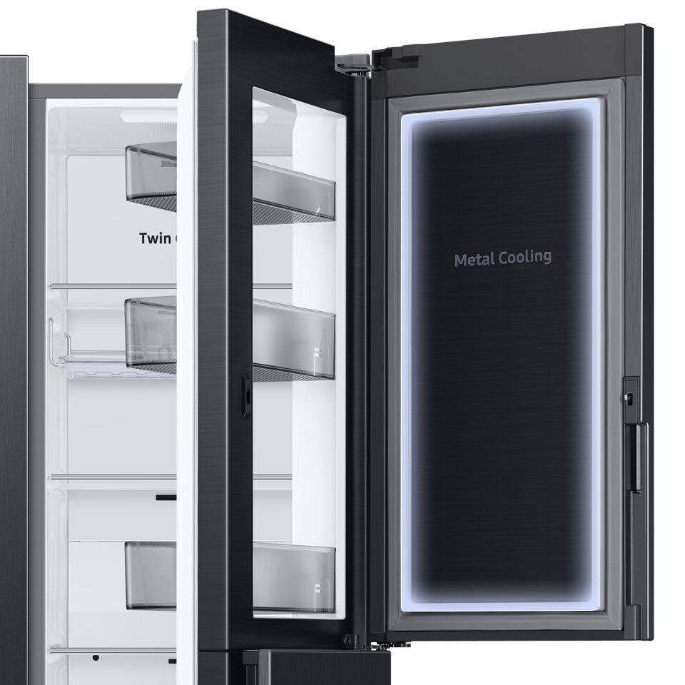 Otwarta lodówka z widocznymi półkami i napisem \'Twin Cooling\' oraz \'Metal Cooling\' na drzwiach. Wnętrze jest jasne, a drzwi mają ciemny kolor z przezroczystymi pojemnikami.