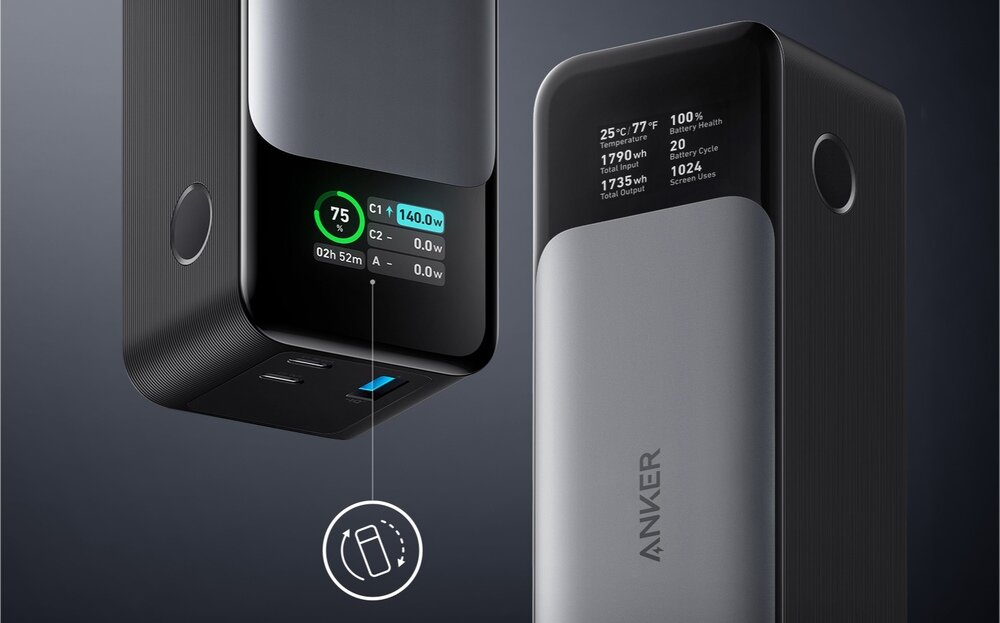 Na obrazie widoczny jest czarny powerbank z wyświetlaczem pokazującym informacje takie jak poziom naładowania i moc wyjściowa. Na obudowie znajduje się logo \'ANKER\'.
