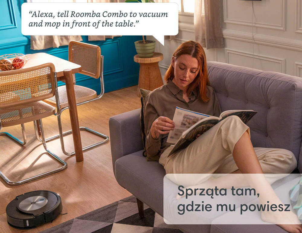 Osoba siedzi na kanapie i czyta magazyn, obok niej na podłodze znajduje się robot sprzątający. Na obrazie widoczny jest tekst: \'Alexa, tell Roomba Combo to vacuum and mop in front of the table.\' oraz \'Sprząta tam, gdzie mu powiesz\'.