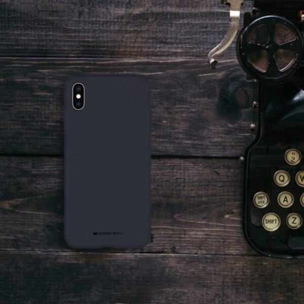 Na drewnianym tle leży ciemnoniebieskie etui na telefon z logo \'GOOSPERY\'. Obok znajduje się fragment starej maszyny do pisania.