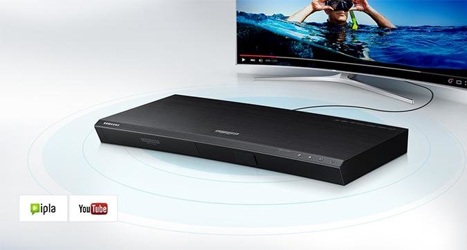 Odtwarzacz UHD Blu-ray K8500 podłączony do telewizora SUHD. W Lewym dolnym roku ikony IPLA i YouTube.